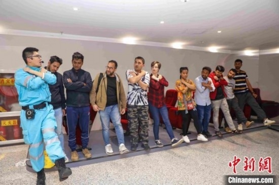 5月9日，工作人員指導(dǎo)留學(xué)生練習(xí)逃生技巧。張鷹 攝