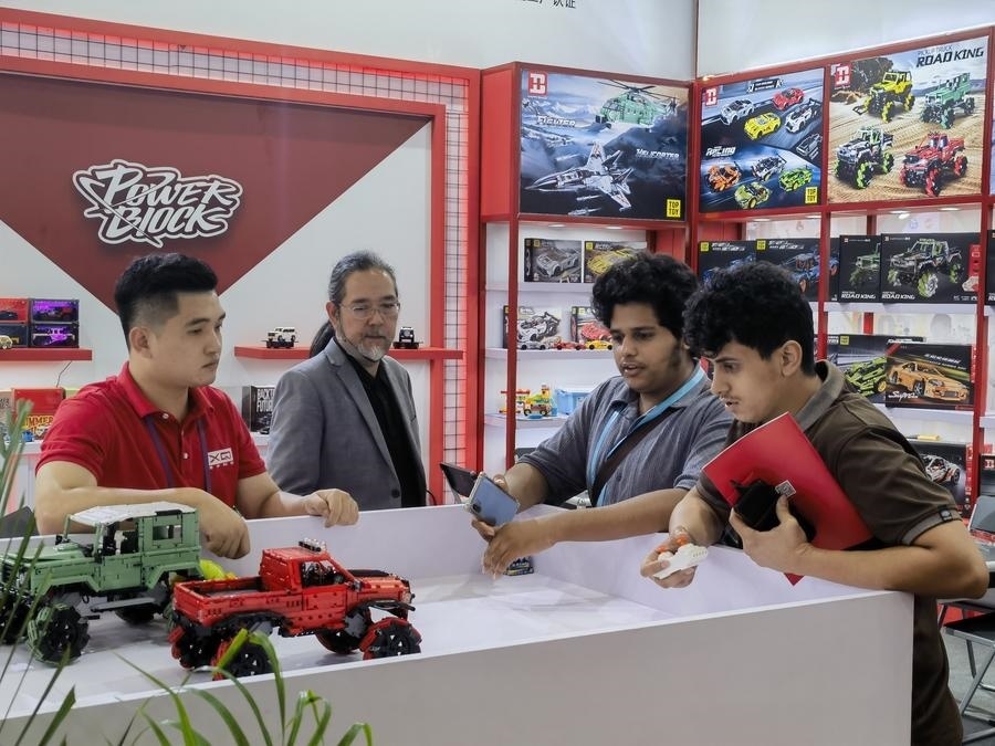 在第135屆廣交會第三期現(xiàn)場，采購商在廣東信宇科技股份有限公司展位選購、體驗積木遙控車產品（5月2日攝）。新華社記者 洪澤華 攝