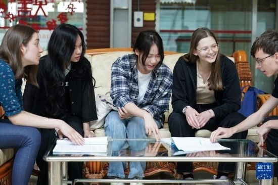 4月28日，宋智孝（右二）和胡靈月（左一）在北京首都師范大學校園內與同學交流。新華社記者 彭子洋 攝