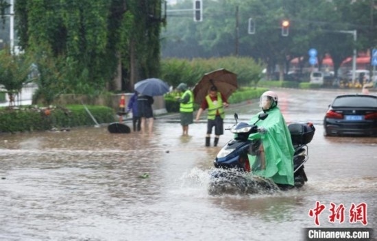5月10日，廣西沿海遭遇強(qiáng)降雨。圖為欽州市民眾在積澇中出行。陸敏 攝