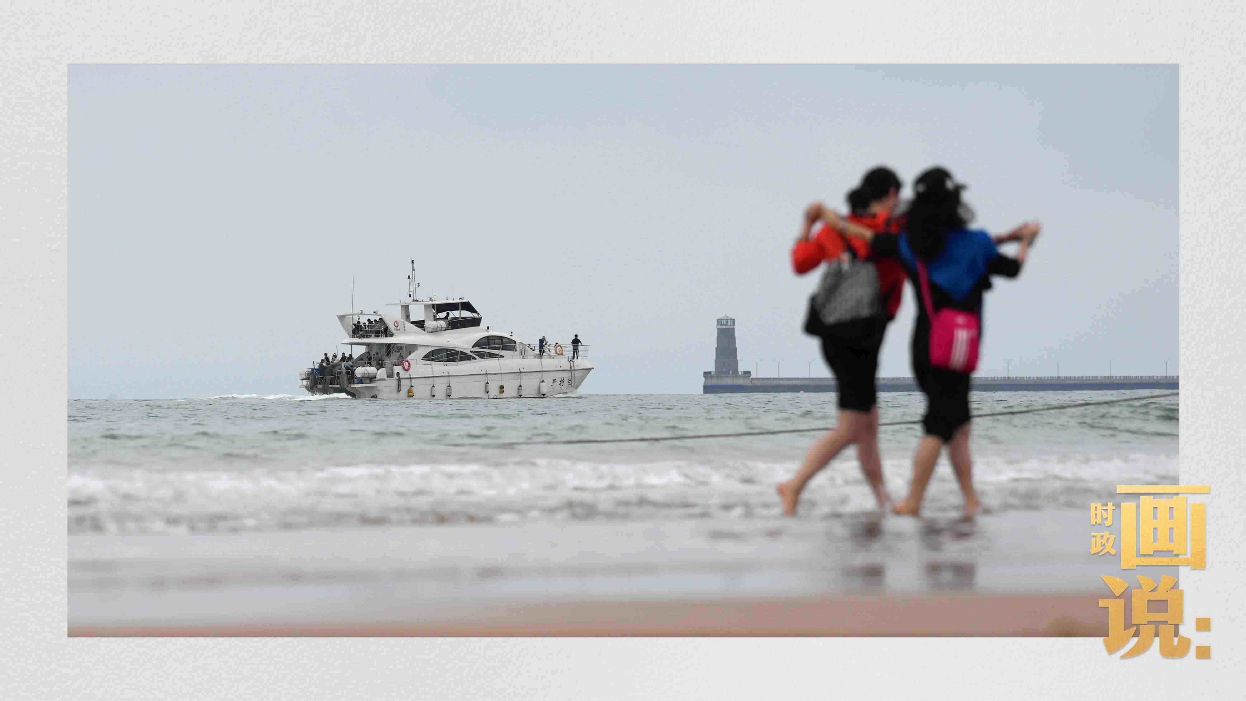 △日照陽光海岸綠道上的萬平口景區(qū)，一對游客在海浪中翩然起舞。