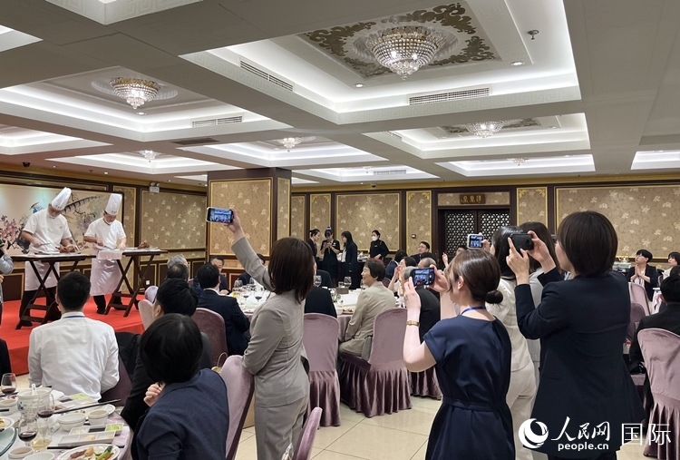 國家級非物質(zhì)文化遺產(chǎn)、全聚德片鴨工藝吸引代表團成員拍照留念。