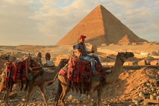 1月24日，商販騎駱駝離開埃及吉薩金字塔景區(qū)。新華社記者 隋先凱 攝