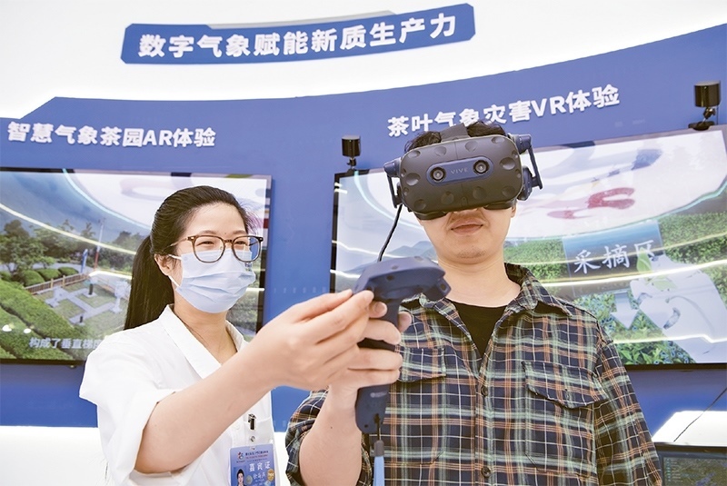2024年5月23日，第七屆數(shù)字中國建設峰會現(xiàn)場體驗區(qū)在福州海峽國際會展中心向專業(yè)觀眾開放。本次現(xiàn)場體驗區(qū)圍繞本屆峰會主題“釋放數(shù)據(jù)要素價值，發(fā)展新質生產力”，設置“數(shù)字惠民”、“數(shù)字能力”、“數(shù)字基礎”、“數(shù)字生態(tài)”、“數(shù)字賦能”五大板塊。圖為一名觀眾（右）在數(shù)字氣象賦能新質生產力展臺上進行體驗。 新華社記者 魏培全/攝
