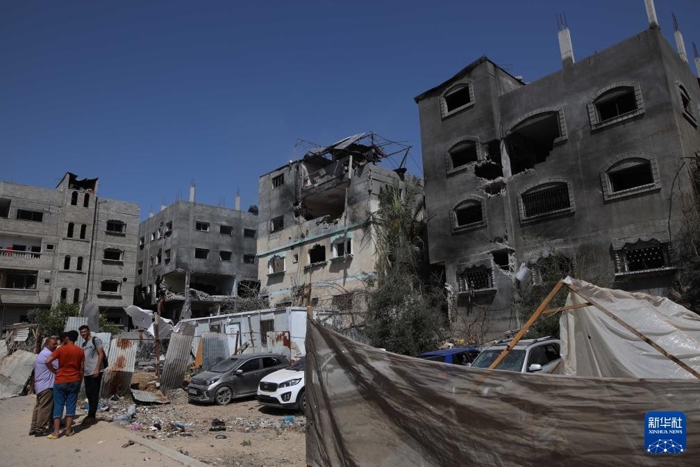 這是6月8日在加沙地帶中部努賽賴特難民營拍攝的在以軍襲擊中受損嚴(yán)重的房屋及車輛。新華社發(fā)（馬爾萬·達(dá)烏德攝）