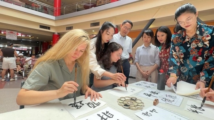 羅馬尼亞友人在活動(dòng)現(xiàn)場(chǎng)學(xué)寫漢字。中國(guó)駐羅馬尼亞大使館領(lǐng)僑處供圖