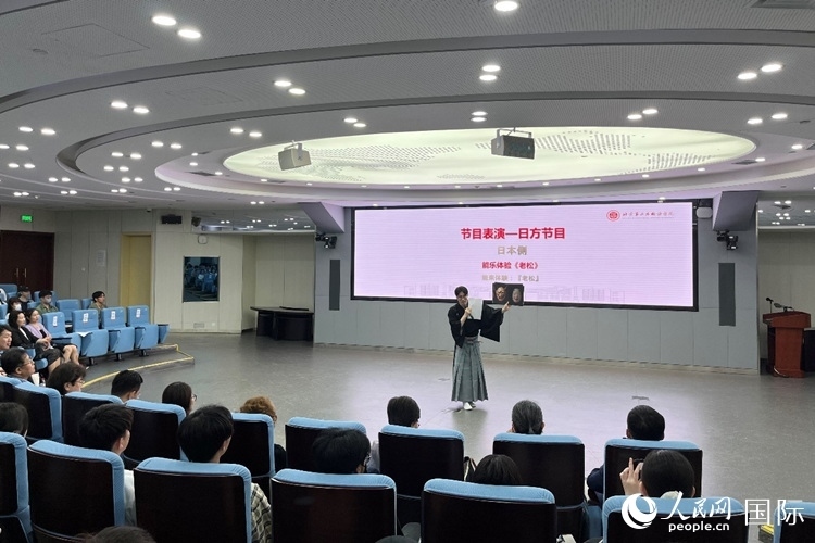 日本大學(xué)生介紹能樂知識(shí)。人民網(wǎng)記者 陳思攝