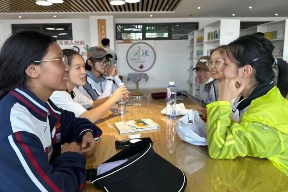 2023年7月10日，在果洛西寧民族中學，上海市大同中學學生（右）與果洛西寧民族中學學生交流。新華社發(fā)（果洛州教育局供圖）