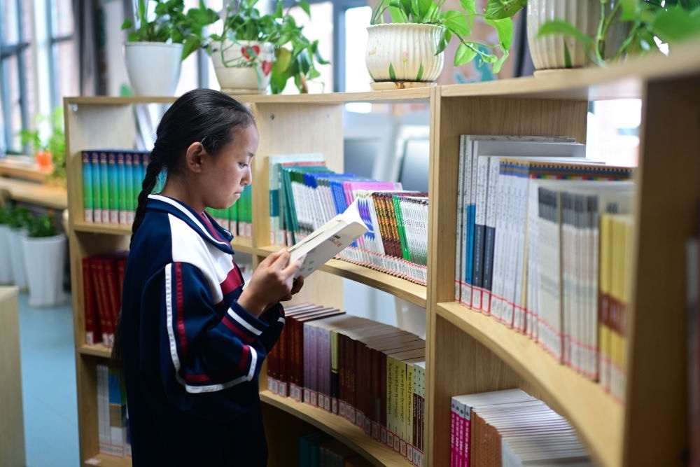 6月18日，果洛西寧民族中學(xué)學(xué)生尼東拉毛在圖書室看書。
