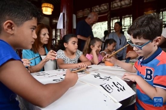 7月4日，在馬耳他桑塔露琪亞市的中國古典園林“靜園”，人們體驗中國書法。新華社發(fā)（喬納森·博格 攝）