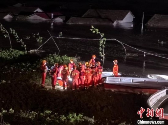  7月6日凌晨3時(shí)，在湖南岳陽華容縣團(tuán)洲垸洞庭湖一線堤防，救援人員剛剛完成一次救援任務(wù)，遠(yuǎn)處是被淹的民房。中新社記者 白祖偕 攝