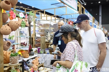 游客在蘭納博覽會(huì)特色展位上選購(gòu)工藝品。人民網(wǎng)記者楊一攝