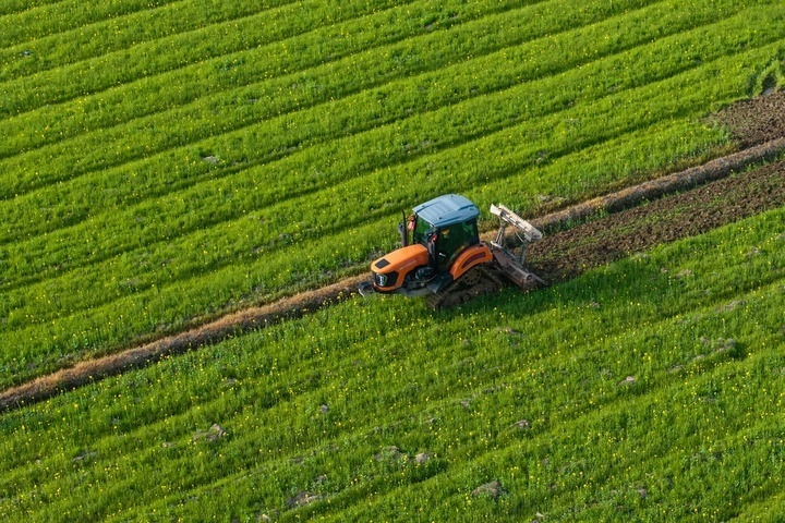 2024年3月19日，在湖南省常德市鼎城區(qū)謝家鋪鎮(zhèn)港中坪村，村民駕駛農(nóng)機(jī)翻耕田地（無(wú)人機(jī)照片）。新華社記者 陳思汗 攝
