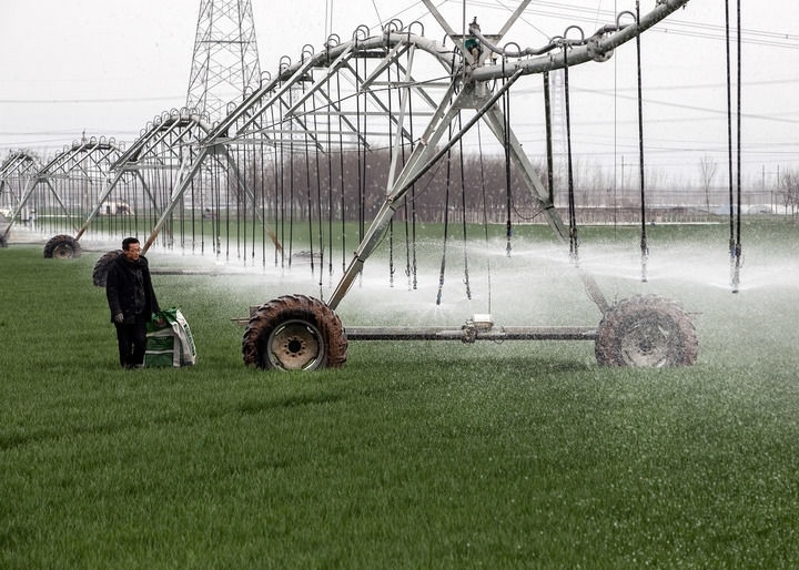 2024年3月18日，在河南省焦作市博愛(ài)縣孝敬鎮(zhèn)東原莊村瑞輝家庭農(nóng)場(chǎng)，村民使用全自動(dòng)指針式噴灌機(jī)進(jìn)行澆灌作業(yè)。新華社發(fā)（程全攝）