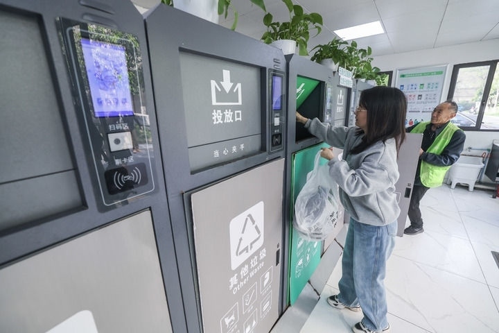 2024年4月10日，在浙江省湖州市吳興區(qū)飛英街道新華府小區(qū)內(nèi)，居民在垃圾分類智能系統(tǒng)的指導(dǎo)下進(jìn)行垃圾分類投放，居民的投放情況將實(shí)時(shí)匯總到智慧服務(wù)平臺(tái)，會(huì)有相應(yīng)的積分獎(jiǎng)勵(lì)。新華社記者 徐昱 攝