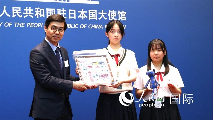 日本小大使向中國駐日本大使館臨時代辦施泳贈送當?shù)靥厣Y品。人民網(wǎng) 許可攝