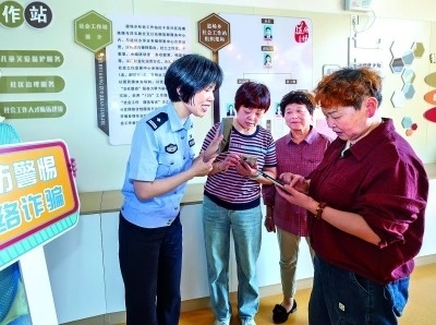 浙江湖州民警指導(dǎo)居民加入湖州“e企安”微信群，實(shí)時(shí)接收反詐信息。新華社發(fā)