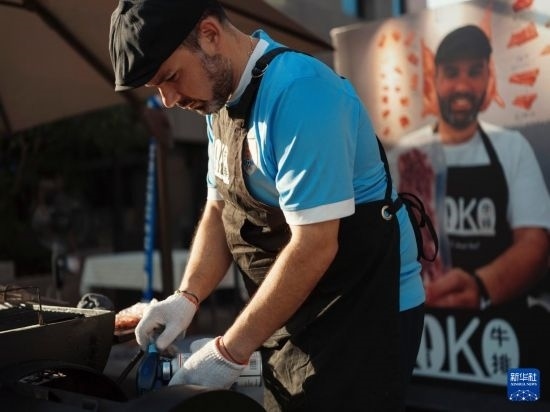 7月19日，在蕪湖古城，馬丁在當天舉行的啤酒節(jié)上制作牛排。新華社發(fā)（繆雨晨 攝）