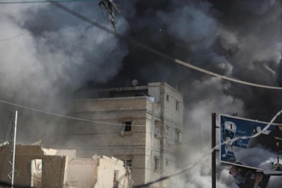 7月21日，在加沙地帶中部的努賽賴特難民營，遭以軍空襲的建筑冒出滾滾濃煙。新華社發(fā)（馬爾萬·達(dá)烏德攝）