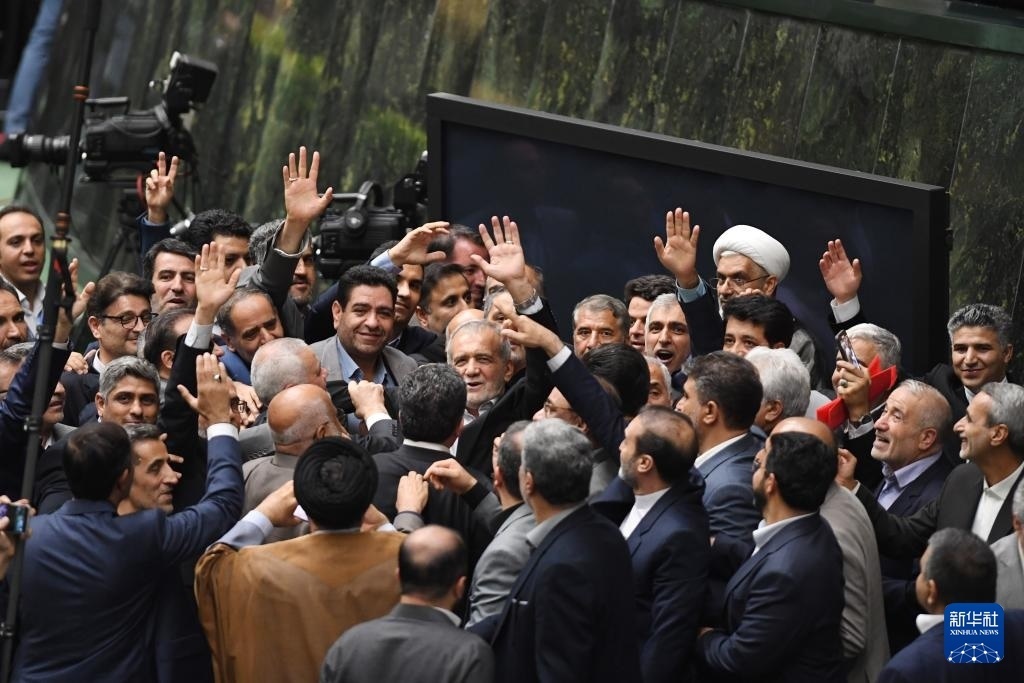 7月30日，在伊朗德黑蘭的伊朗議會(huì)，佩澤希齊揚(yáng)（中）離開(kāi)總統(tǒng)就職典禮現(xiàn)場(chǎng)時(shí)揮手致意。新華社記者 沙達(dá)提 攝