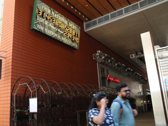 2023年5月29日，人們經(jīng)過(guò)美國(guó)紐約曼哈頓的“國(guó)債鐘”?！皣?guó)債鐘”是一個(gè)大型計(jì)數(shù)器，它實(shí)時(shí)更新美國(guó)的公共債務(wù)總額，并顯示出每個(gè)美國(guó)家庭所要負(fù)擔(dān)的數(shù)額。 新華社記者劉亞南攝