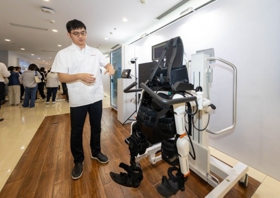 2024年5月24日，在位于上海市嘉定區(qū)的上海交通大學(xué)醫(yī)學(xué)院附屬瑞金醫(yī)院腫瘤質(zhì)子中心，工作人員介紹由瑞金醫(yī)院醫(yī)生和醫(yī)療公司共同研發(fā)的用于恢復(fù)患者下肢的醫(yī)療機(jī)器人。新華社記者 王翔 攝