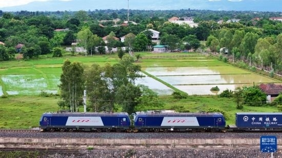 8月5日，由老撾籍火車司機(jī)獨(dú)立駕駛的滿載貨物的列車駛出萬象站，向中國昆明進(jìn)發(fā)（無人機(jī)照片）。新華社發(fā)（楊永全 攝）