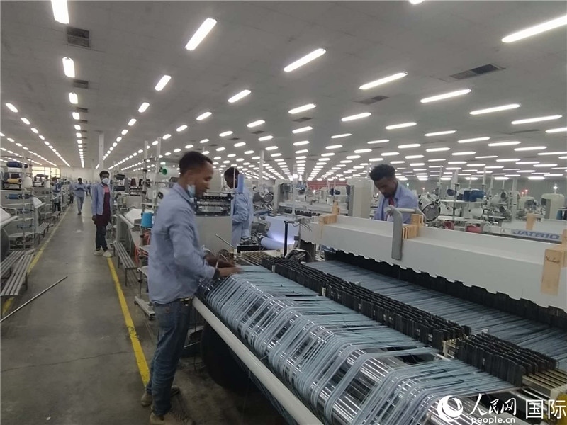 無(wú)錫金茂埃塞面料廠車(chē)間內(nèi)，當(dāng)?shù)毓と苏谝唤z不茍地作業(yè)。人民網(wǎng)記者 黃培昭攝