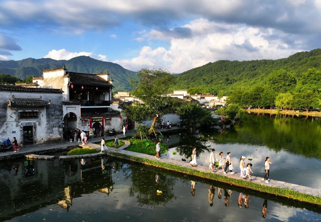 2024年7月7日，游客在安徽省黃山市黟縣宏村游玩。新華社記者杜宇攝