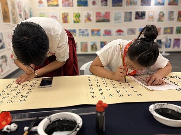 參加本次展覽的青少年在現(xiàn)場進(jìn)行書法創(chuàng)作。主辦方供圖