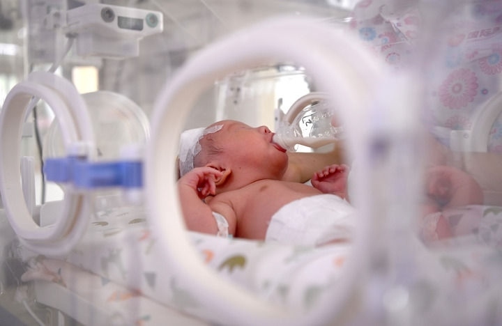 2024年6月1日，在西安國際醫(yī)學(xué)中心醫(yī)院新生兒科病房，護士為新生兒喂奶。 新華社記者 劉瀟 攝