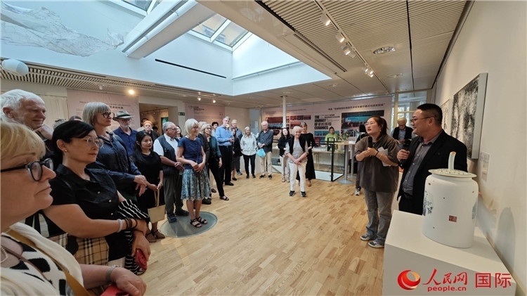 參展人、景德鎮(zhèn)陶瓷大學美術(shù)學院副院長邵長宗（右一）向來賓介紹參展作品。人民網(wǎng)記者 殷淼攝