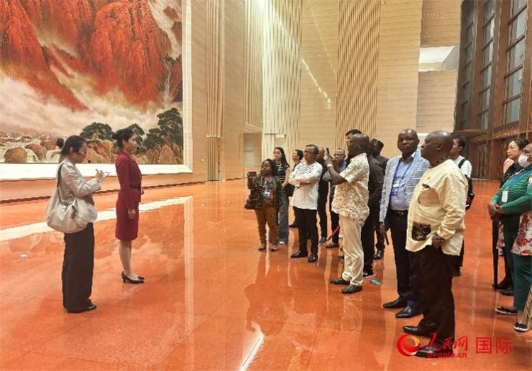 代表團(tuán)在入口處聽取講解。人民網(wǎng) 曹欣悅攝