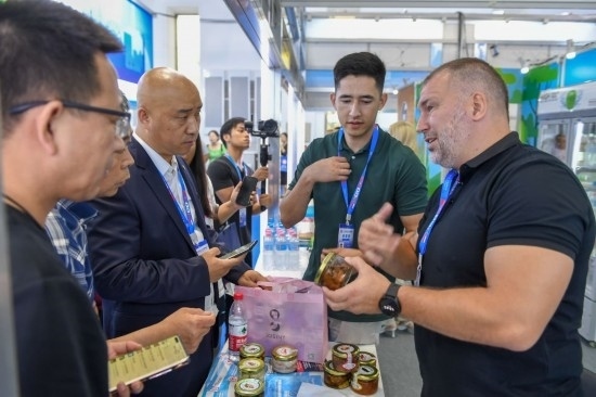 2023年8月23日，在第十四屆中國—東北亞博覽會東北亞商品館，俄羅斯參展商向參觀者介紹商品。