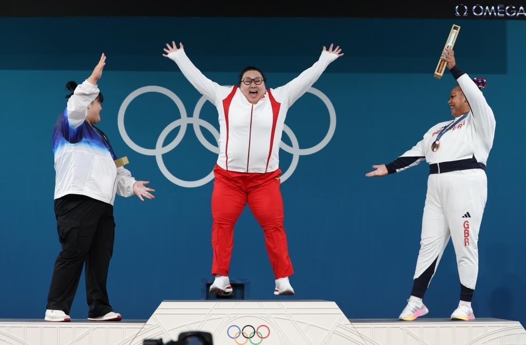 中國選手李雯雯（中）在巴黎奧運(yùn)會舉重女子81公斤以上級頒獎儀式中登上領(lǐng)獎臺（2024年8月11日攝）。新華社記者 楊磊 攝