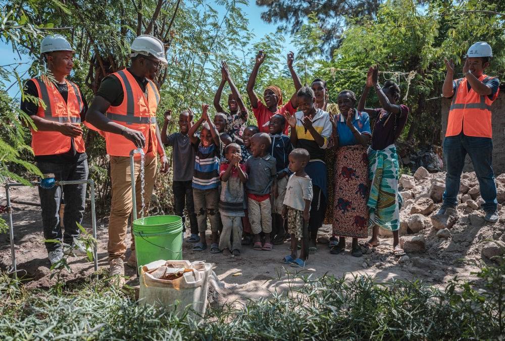 2023年6月13日，在坦桑尼亞姆萬扎省米松圭，工作人員接通水管后贏得當地居民鼓掌歡呼。新華社記者 王冠森 攝