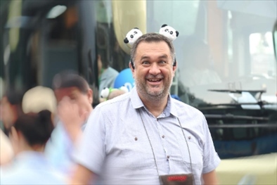 參訪熊貓谷前，塞爾維亞“一帶一路”研究所所長(zhǎng)博揚(yáng)·拉利奇戴上熊貓頭飾。（李佩藺 攝）