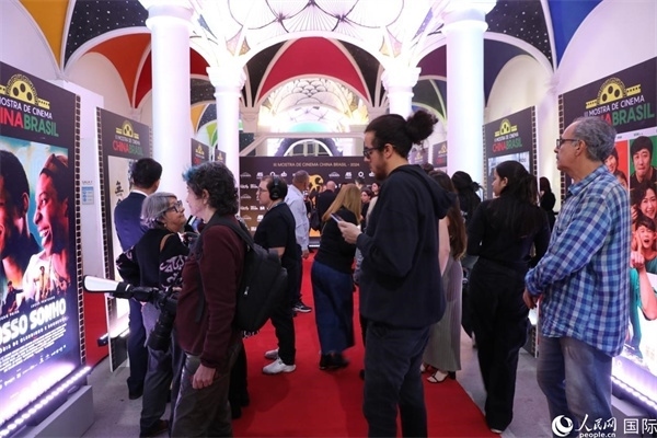 為期4天的第三屆中國(guó)－巴西電影展期間，來(lái)自中巴兩國(guó)的14部參展影片受到巴西電影愛(ài)好者和社會(huì)各界人士好評(píng)，圖為當(dāng)?shù)赜^眾在影展舉辦地巴西里約熱內(nèi)盧勞拉—阿爾維姆文化之家的迎賓廳欣賞參展電影海報(bào)。 人民網(wǎng)記者 陳一鳴攝