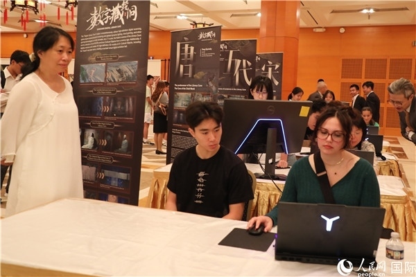 在活動(dòng)現(xiàn)場(chǎng)，當(dāng)?shù)孛癖婓w驗(yàn)“數(shù)字藏經(jīng)洞”云游戲，沉浸式體驗(yàn)敦煌文化。 人民網(wǎng)記者 李志偉攝