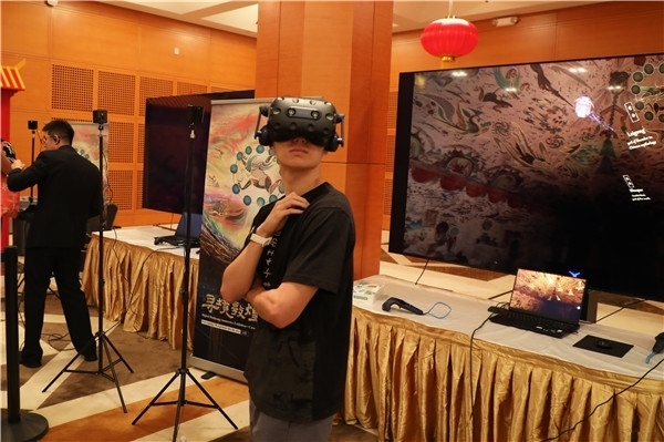 1、在本次活動(dòng)的展覽現(xiàn)場(chǎng)，敦煌研究院與騰訊展示了“數(shù)字藏經(jīng)洞”和“尋境敦煌”等創(chuàng)新互動(dòng)產(chǎn)品。圖為當(dāng)?shù)孛癖娡ㄟ^(guò)VR虛擬游覽洞窟。 人民網(wǎng)記者 李志偉攝