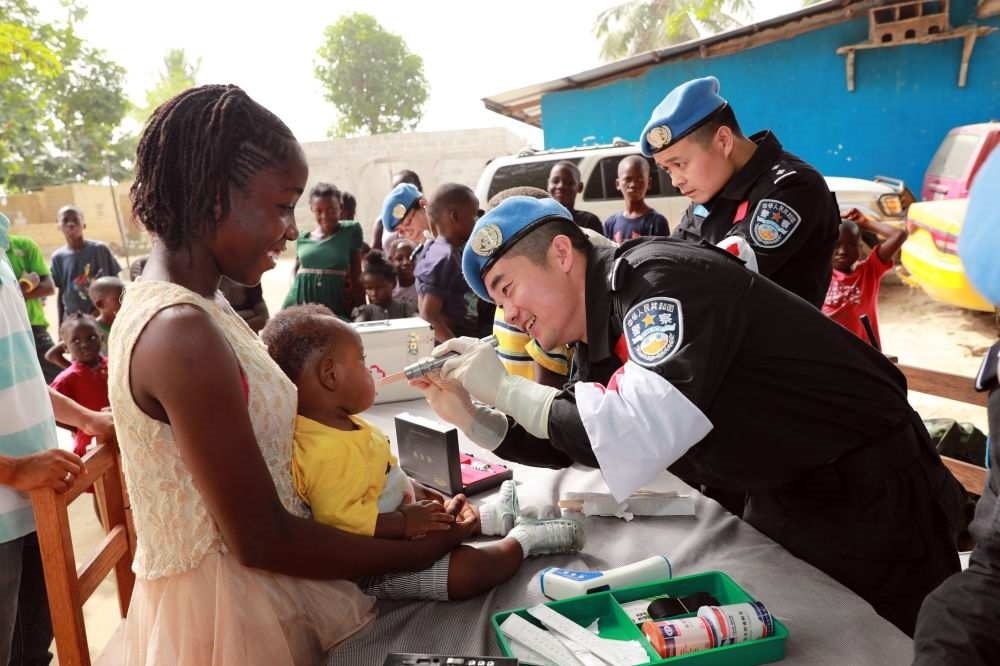2017年12月28日，在利比里亞蒙羅維亞，中國(guó)維和警察防暴隊(duì)醫(yī)療人員為兒童做口腔檢查。