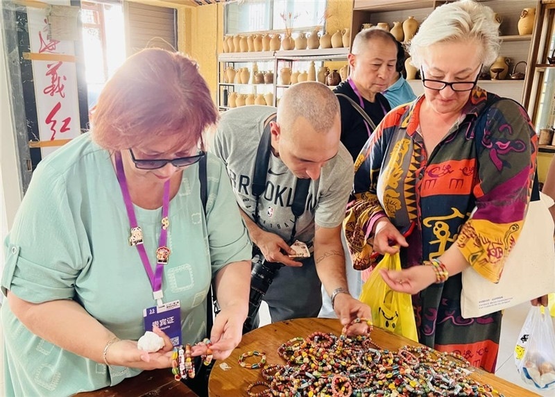 歐亞媒體考察團(tuán)成員在母氏陶藝館內(nèi)挑花了眼，色彩絢麗、質(zhì)地均勻的陶藝手串讓他們愛不釋手?！斑@里的東西都太實(shí)惠了！”塔吉克斯坦《索格特真理報(bào)》政論部主任娜塔利婭·多羅費(fèi)耶娃說?；宓奶厣a(chǎn)品物美價(jià)廉，讓考察團(tuán)成員為家人好友買到了心儀的禮物，也為此次以四川成都為起點(diǎn)，路經(jīng)南充、廣安至貴州遵義的考察行程畫上了圓滿句號(hào)。（張亞欣攝）