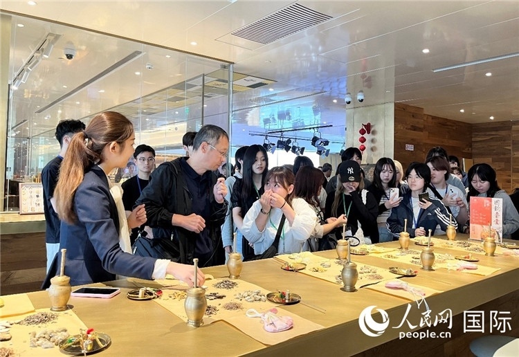 1. 日中友好協(xié)會青年代表團(tuán)一行學(xué)習(xí)中醫(yī)香囊制作工序。（人民網(wǎng)記者陳思 攝）