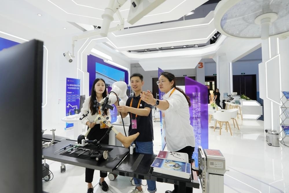 9月11日，一位媒體記者（中）在2024年服貿(mào)會(huì)國(guó)家會(huì)議中心會(huì)場(chǎng)體驗(yàn)北京納通科技集團(tuán)有限公司的膝關(guān)節(jié)置換手術(shù)機(jī)器人。新華社記者鞠煥宗 攝