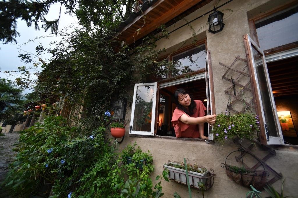 8月29日，在福建省屏南縣熙嶺鄉(xiāng)，龍?zhí)洞濉靶麓迕瘛泵泛暝诖蚶碜约航洜I的民宿外墻裝飾花盆。新華社記者姜克紅 攝