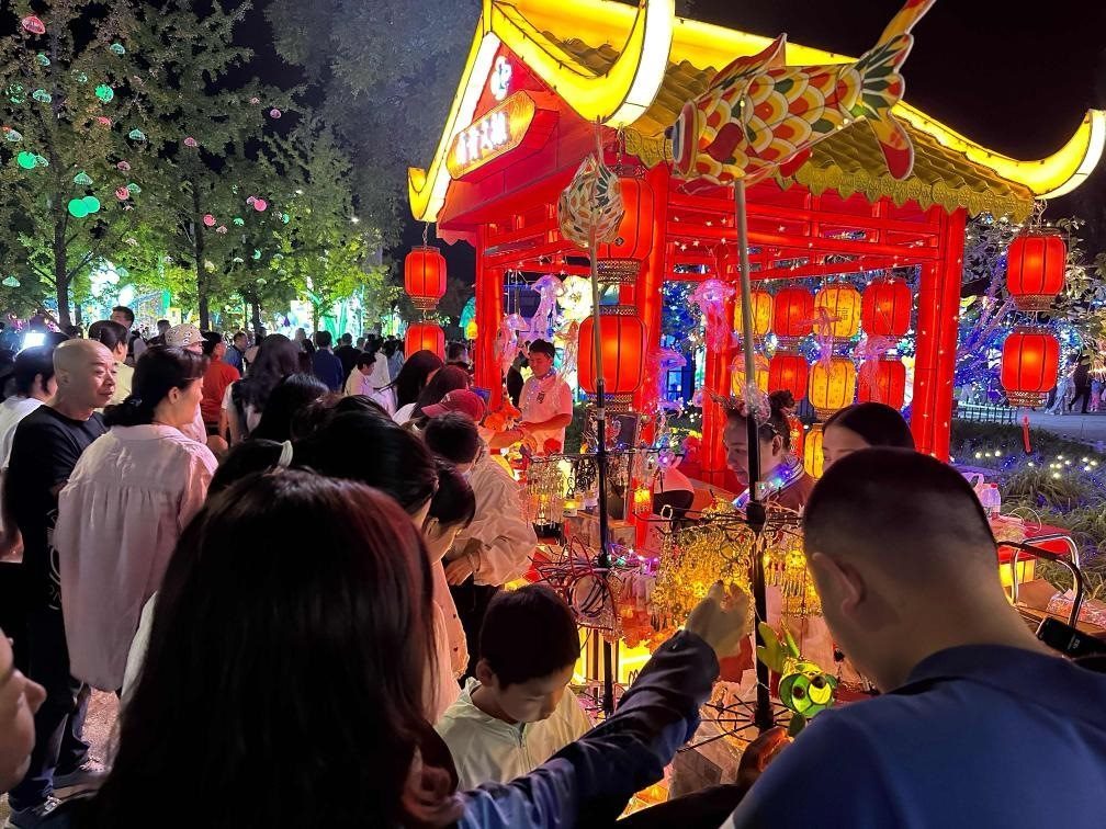 市民游客在2024年北京中秋國(guó)慶彩燈游園會(huì)上選購(gòu)特色文創(chuàng)商品。新華社記者楊淑君 攝