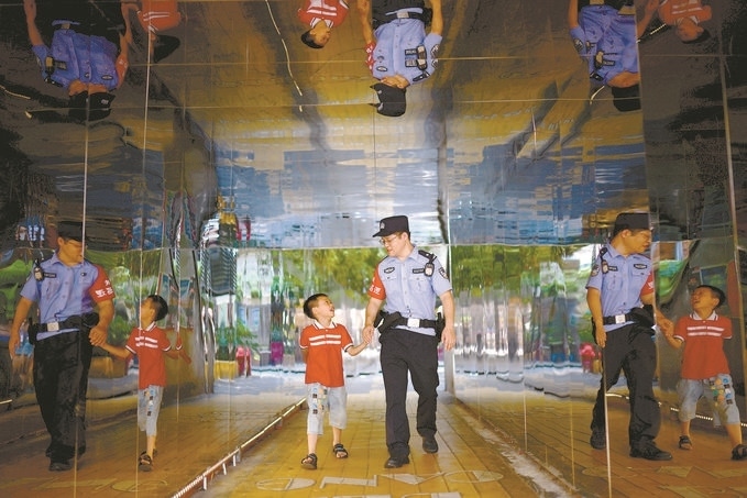 ?7月16日，重慶市公安局江北區(qū)分局一名民警在巡邏途中遇到一個(gè)獨(dú)自玩耍的小男孩，民警將其送回家。王洪平攝