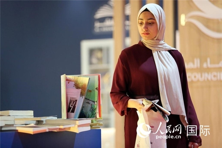 一名女性走過展臺。人民網(wǎng) 奧馬爾·哈利勒攝