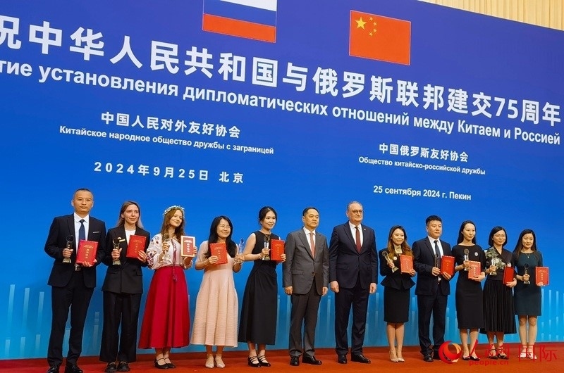 楊萬明會長和莫爾古洛夫大使為10位中俄青年友好微視頻創(chuàng)意大賽獲獎代表頒獎。人民網(wǎng)記者 李明琪攝