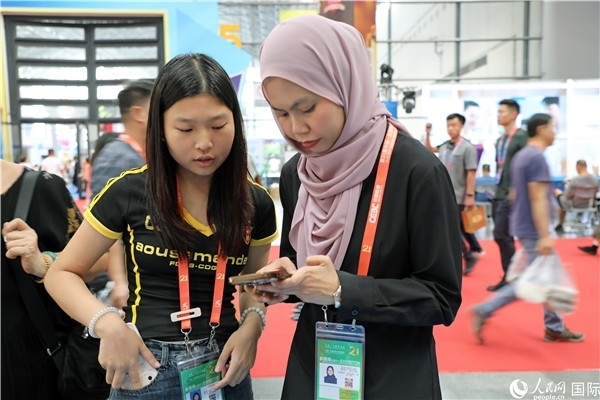 東博會(huì)現(xiàn)場，馬來西亞展商在同中方工作人員交談。人民網(wǎng)記者 趙益普攝